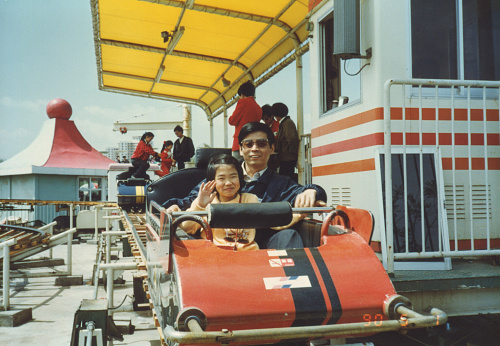 1990.5.1, CHINA, Beijing.  Father takes his daughter on a rollercoaster in the playground.