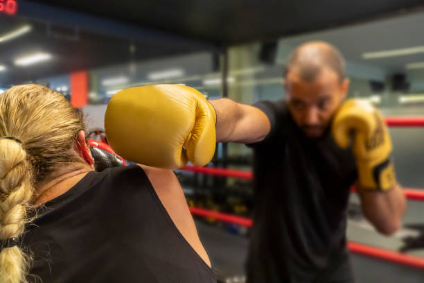 istock Young woman working out by practicing kickboxing. Concentrated training at the gym. 1321706493