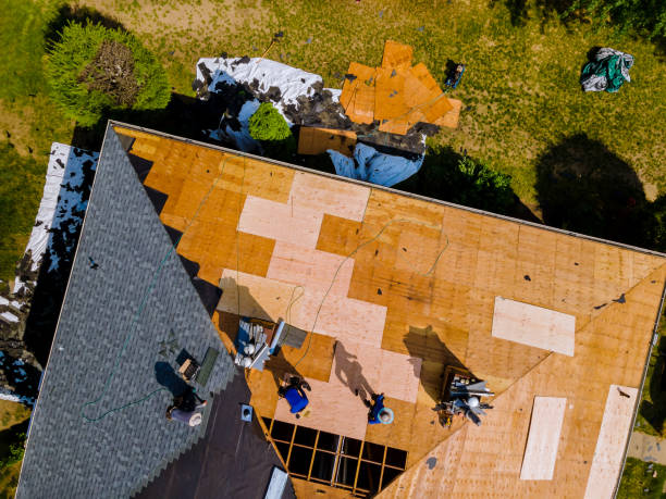 Roof construction repairman on a residential apartment with new roof shingle being applied stock photo