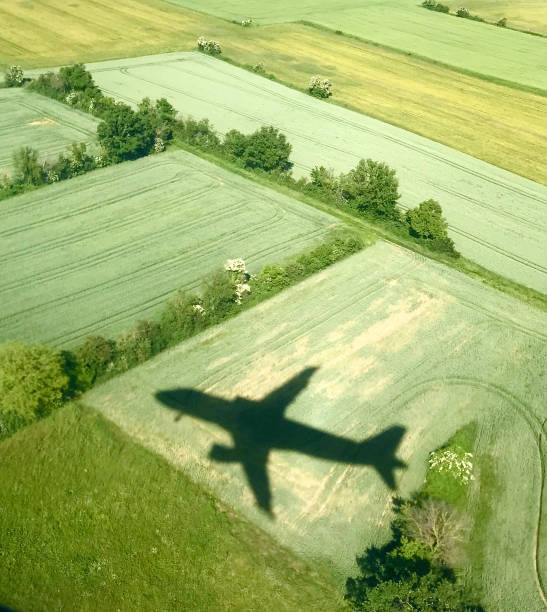 Shadow of a passenger plane in the middle of the fields in spring near Saint-Exupéry airport in Lyon, France