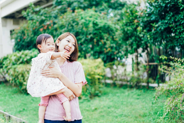 istock Mother playing in the park with her baby 1321709829