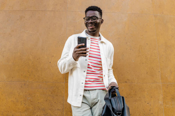 istock Smiling young African-American using mobile phone 1321709954