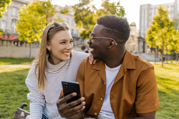 istock Diversity couple using mobile phone outdoors 1321710130