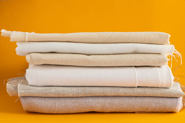 istock natural fabrics stacked in pile lie on a yellow background 1321710150