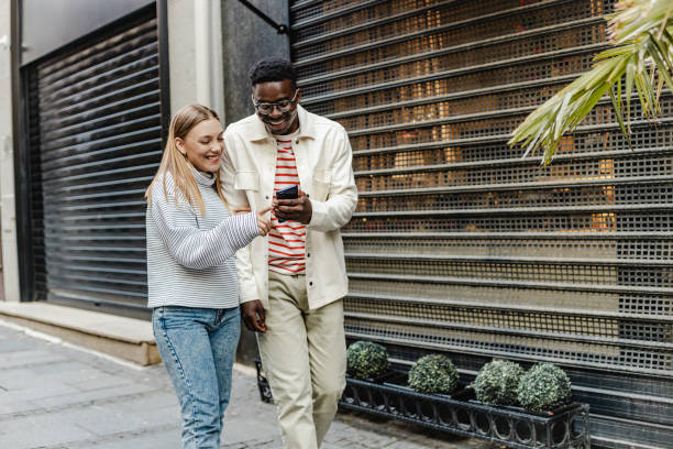 istock Friends walking and using mobile phone on the move 1321710212