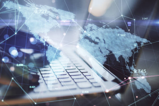 istock Global business and technology concept. Side view and close up of hands at desktop using laptop with glowing digital map. Double exposure. 1321710503
