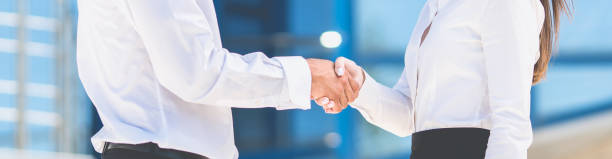 The man and woman handshake the background of the business center The man and woman handshake the background of the business center narrow photos stock pictures, royalty-free photos & images