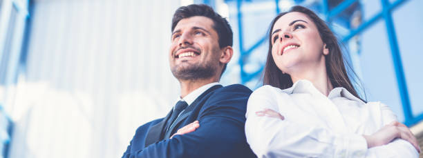 The smile man and woman stand on the background of the office center The smile man and woman stand on the background of the office center narrow photos stock pictures, royalty-free photos & images