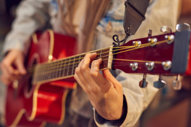 istock Girl in denim jacket playing guitar 1321711602