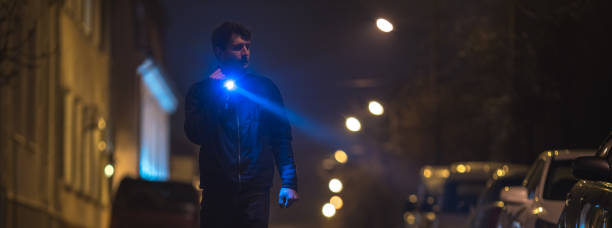 istock The man with a flashlight stand on wet road. Evening night time 1321712044