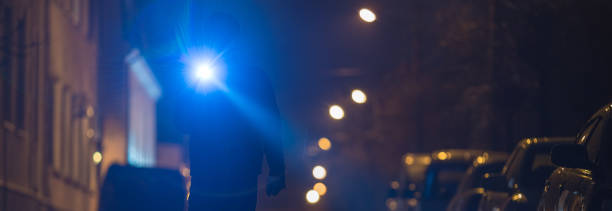 istock The man with a flashlight stand on wet road. Evening night time 1321712058