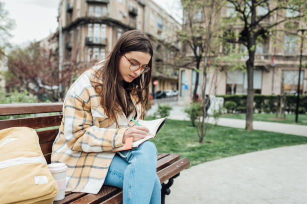 istock Girl sitting in the park and studying 1321712183