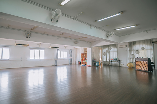 empty dance studio with wooden flooring, window ,barre and mirror