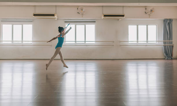 ragazza asiatica cinese che pratica ginnastica ritmica con nastro colorato alla scuola di ginnastica. scuola di balletto. - scuola di danza classica foto e immagini stock