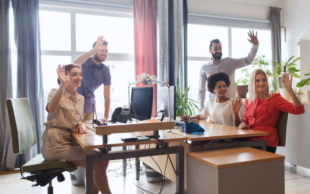 istock happy creative team waving hands in office 1321715444