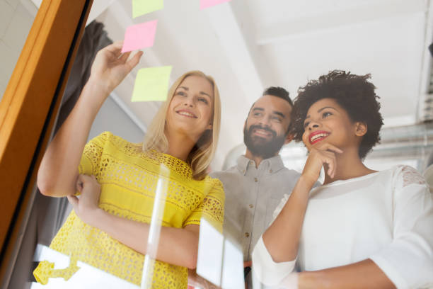 istock happy creative team writing on stickers at office 1321715661