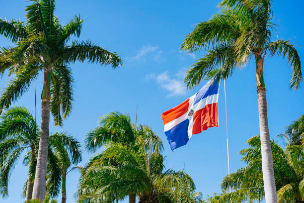 Flag of Dominican Republic waving in the wind against deep blue sky.
