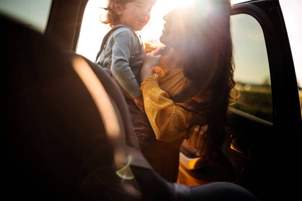 istock Mother tightening seatbelt for kind on back seat 1321719313