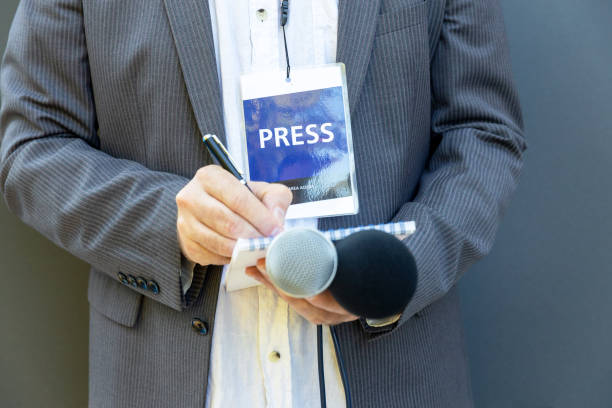 Journalist at media event or news conference, holding microphone, writing notes. Broadcast journalism concept. Public relation (PR) officer working at press conference or media event journalist stock pictures, royalty-free photos & images