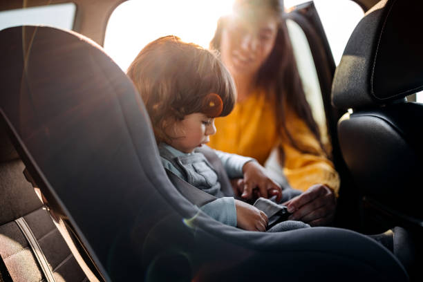 istock Mother tightening seatbelt for kind on back seat 1321720019