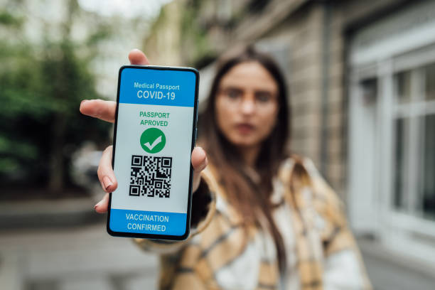 istock Girl holding a smartphone with electronic vaccination certificate on the screen 1321720026