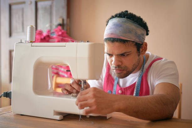 istock Shot of a handsome young tailor sitting alone in his studio and threading the needle in his sewing machine 1321722061