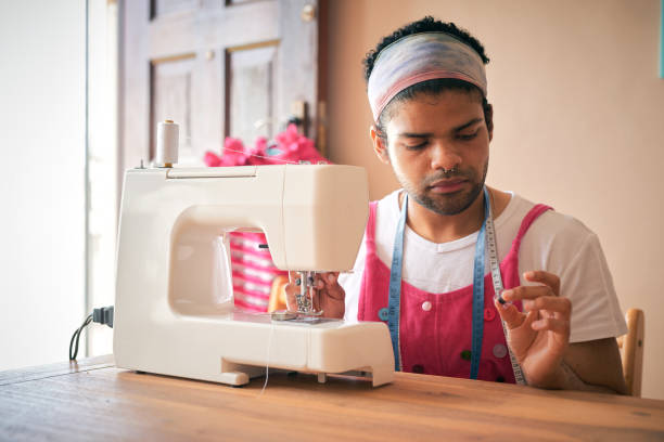 istock Shot of a handsome young tailor sitting alone in his studio preparing his sewing machine 1321722067