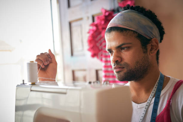 istock Shot of a handsome young tailor sitting alone in his studio preparing his sewing machine 1321722080