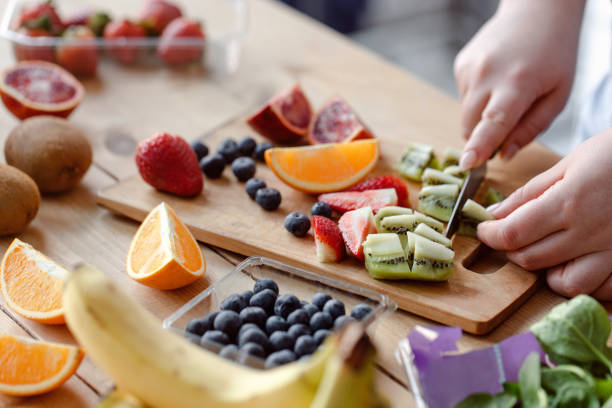 istock Female hans cutting fruit for smoothie. 1321727589