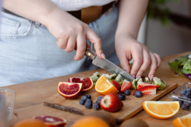 istock Female hans cutting fruit for smoothie. 1321727591