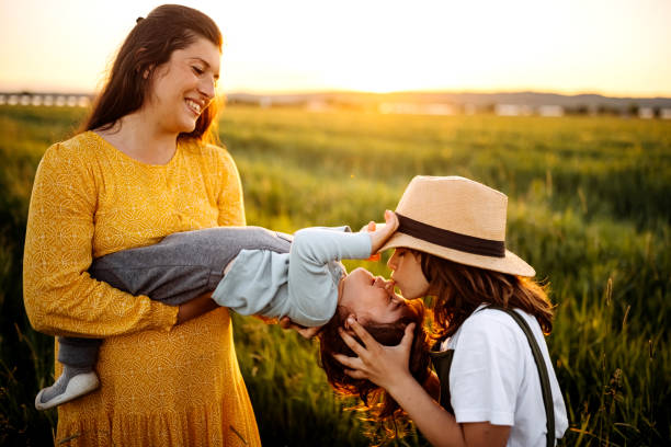 istock Mother playing with kids meadow, it’s sunny and shiny 1321727861