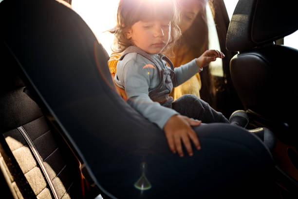 istock Mother tightening seatbelt for kind on back seat 1321728079