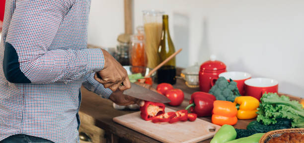 istock African-american man cutting bell pepper in kitchen 1321728173