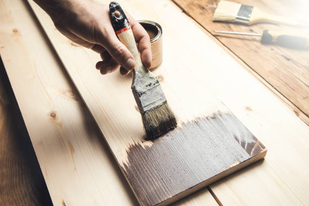 istock man holding paint brush on wood 1321728430