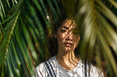 Portrait of beautiful woman with palm tree leaves