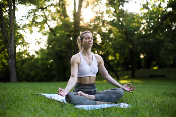 istock Young woman meditating in nature 1321730816