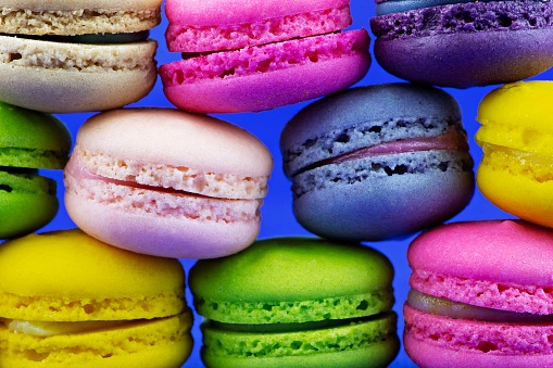 Stack of colorful macaron snacks - blue background.
