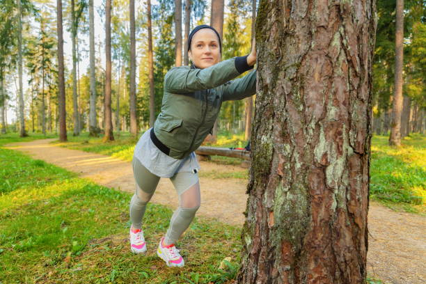 istock Woman doing stretching  near tree in park 1321734401