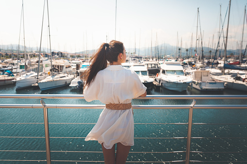 Young woman with a white dress in the marina at Hendaia, Basque Country.