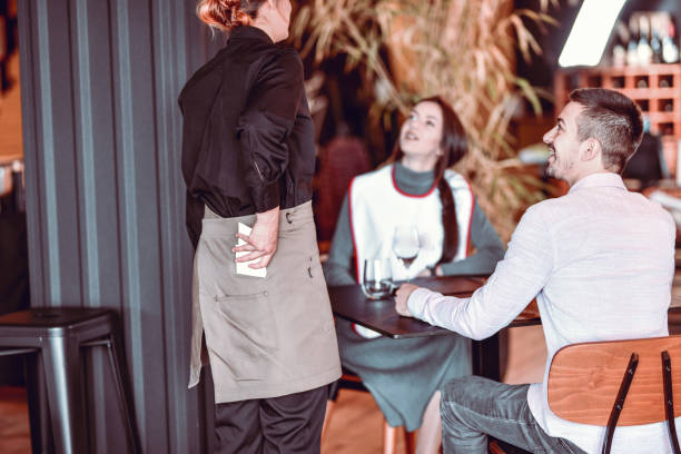istock Modern Waitress With Apron Taking Orders By Happy Guest Couple 1321735149