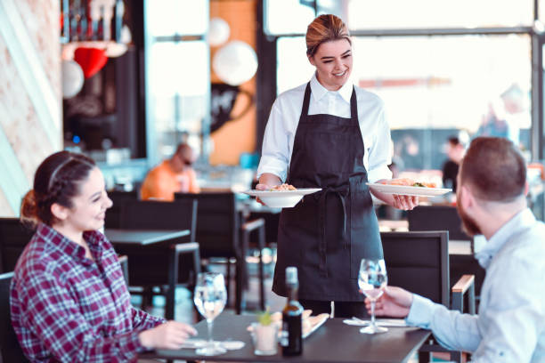 istock Smiling Waitress Bringing Dinner To Happy  Couple 1321736129