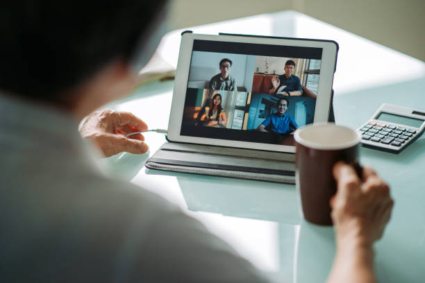 empresaria madura china asiática que trabaja con una tableta digital en una reunión de videoconferencia con auriculares en la oficina - asian cuisine audio fotografías e imágenes de stock