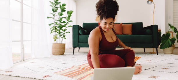 istock Fitness woman using laptop during workout at home 1321741066