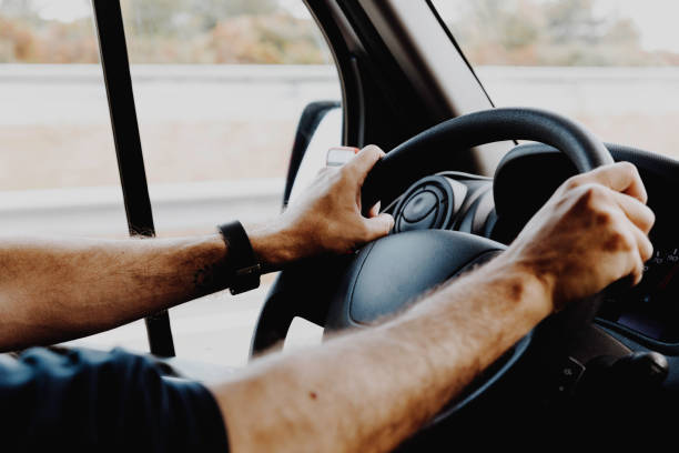 mani maschili che afferrano il volante durante la guida - steering wheel foto e immagini stock