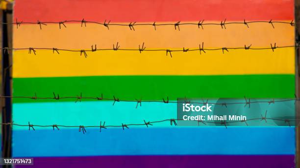 Multicolored Gay Community Flag Behind Barbed Wire Stock Photo - Download Image Now - Homophobia, Russia, Barbed Wire