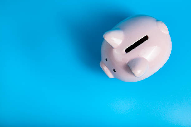 istock Pink pig piggy bank on a blue background. 1321752389