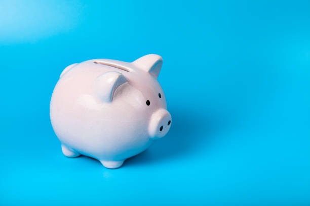 istock Pink pig piggy bank on a blue background. 1321752633