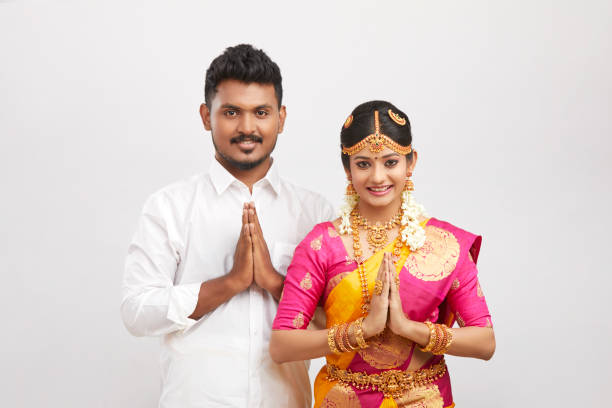 Beautiful happy south Indian couple in traditional dress giving greetings Beautiful happy south Indian couple in traditional dress giving greetings on white. south indian lady stock pictures, royalty-free photos & images