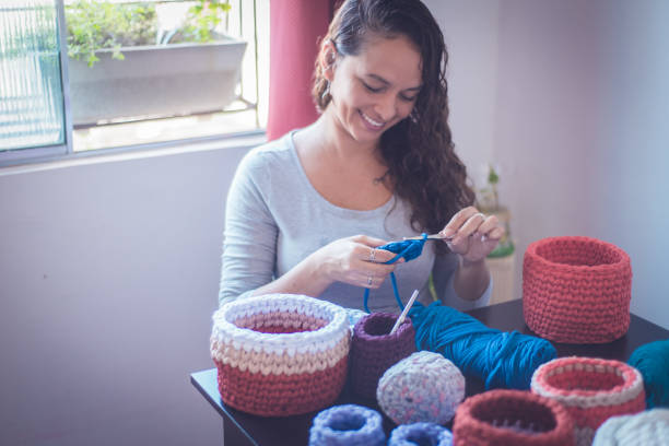 istock Young smiling woman produces crochet crafts. 1321754575