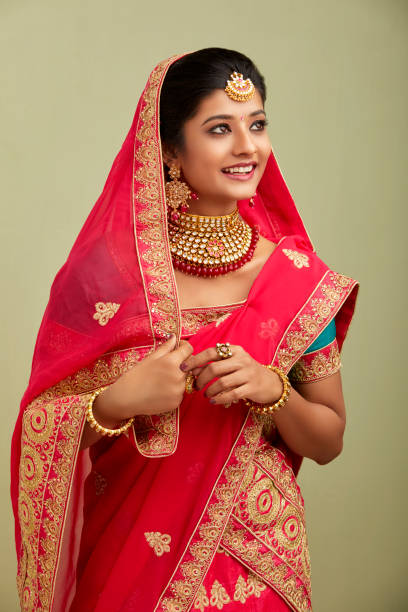 istock Beautiful smiling Indian bride with jewelry in studio shot. 1321755184